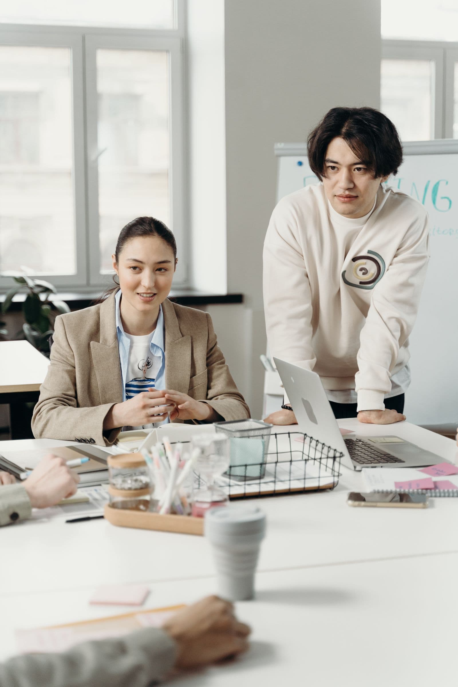 Two colleagues listening during a discussion around an office desk